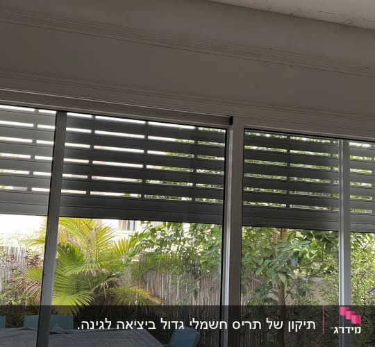 תריסים אופקיים פתוחים למחצה על חלון זכוכית גדול